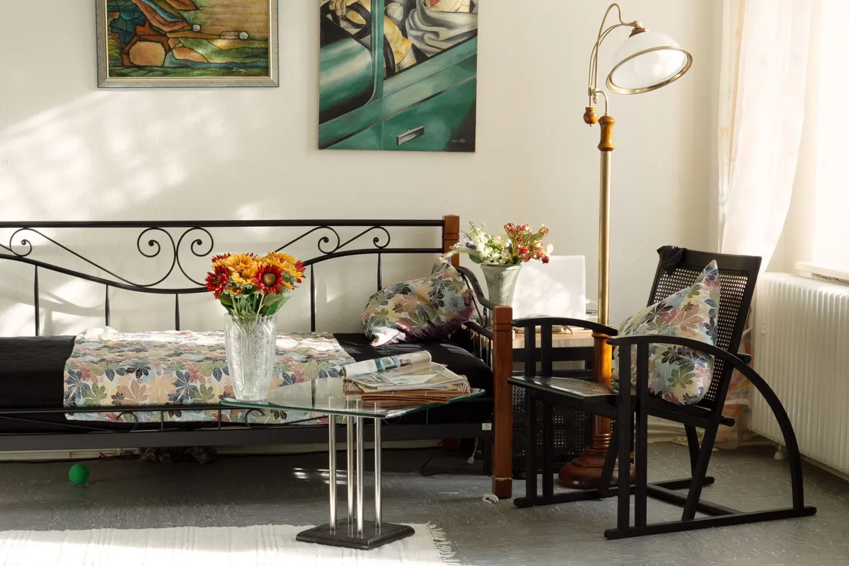 A cozy living room filled with artistic decor and floral pillows, showcasing effective small space design.